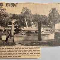          Newspaper clipping from unknown publication; POLICE ON WATCH- During the summer week-ends Saugatuck is busy on land and in water, but the police department covers both. In his patrol cruiser Harbor Master Henry Hungerford exchanges information with Chief of Police Joe Dempski, while Officer Julio Mocini (left, on cruiser) looks on. Since the harbor patrol was instituted last summer, Hungerlord has slowed down the 