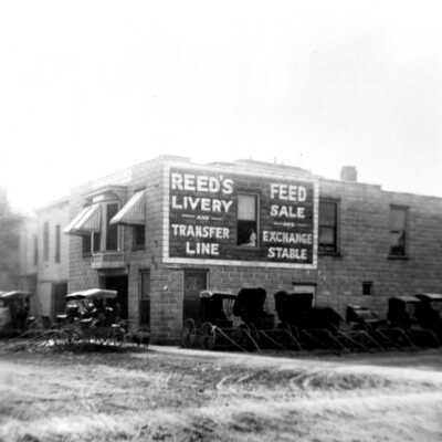REED’S LIVERY, TRANFER LINE, AND FEED STORE Culver Street Saugatuck 1904 Roger Reed was a feed and grain merchant, a liveryman and one of the last operators of the stage line to Allegan. Built on the site of the old Union House Hotel, this was an “exchange stable,” which meant that one could rent a horse with buggy at this location and drop it off at another location. As the trade was overtaken by the automobile Reed began to phase out the business. By 1914 he had moved into auto repair.: Reeds Livery ca 1900