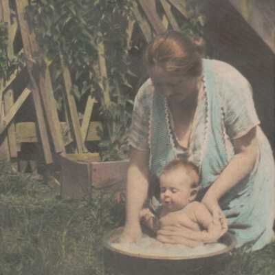Nancy Jane (Loar) Meek bathing her grandson Sellers Burdette Carpenter