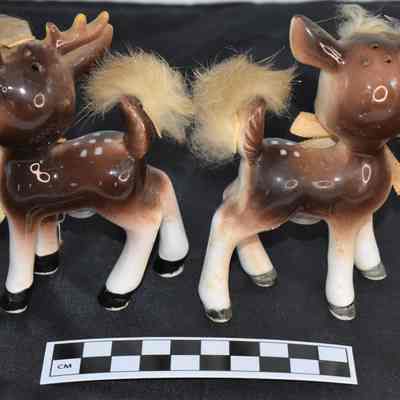 Back and size comparison of deer salt and pepper shakers.