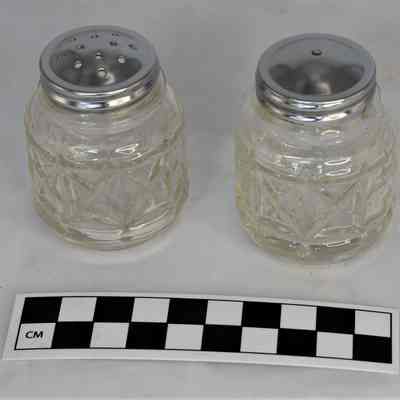 Other side and size comparison of pressed glass salt and pepper shakers.