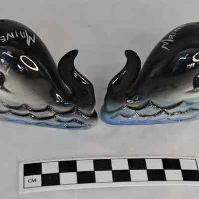 Other side and size comparison of whale salt and pepper shakers.