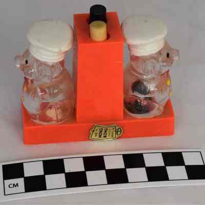 Other side and size comparison of plastic pig salt and pepper shaker set.