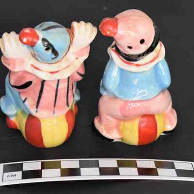 Back and size comparison of clown salt and pepper shakers.