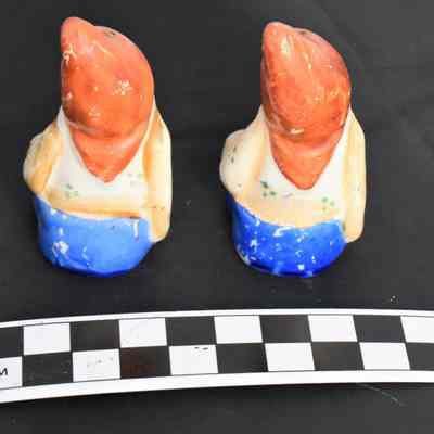 Back and size comparison of gnome salt and pepper shakers.
