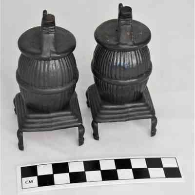 Back and size comparison of pot belly stove shakers.