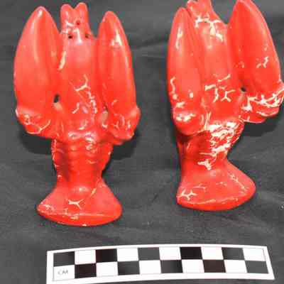 Back and size comparison of lobster salt and pepper shakers.