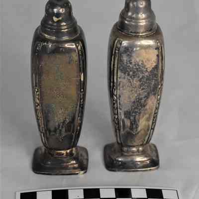 Back and size comparison of silverplate salt and pepper shakers.