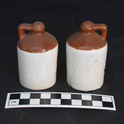 Back and size comparison of the salt and pepper shakers with a yellow bird and barn design.