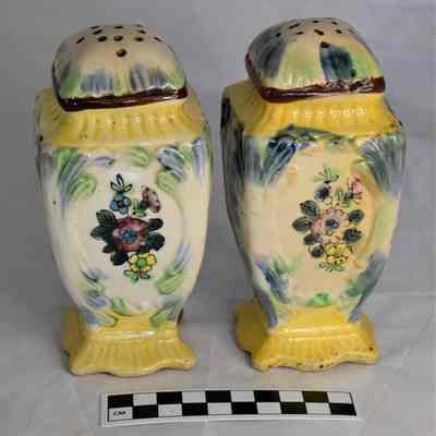 Back and size comparison of large floral salt and pepper shakers.
