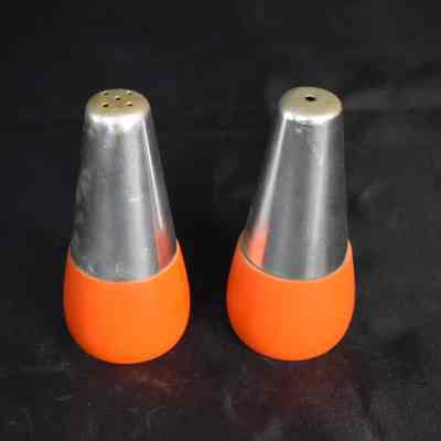 Vintage aluminum salt and pepper shakers with a wooden base. Made in Japan.