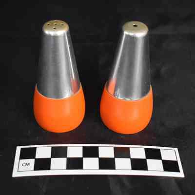 Flipped view and size comparison of the aluminum salt and pepper shakers with a wooden base.
