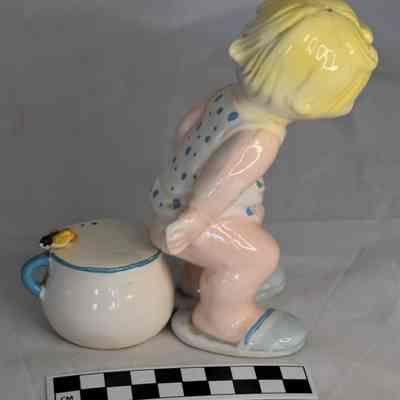Back and size comparison of child / potty salt and pepper shakers.