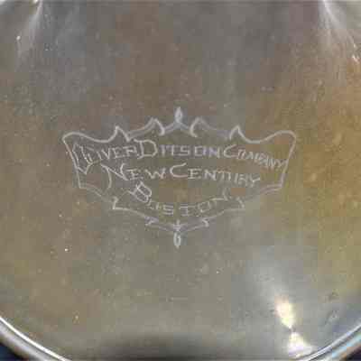 The "OLIVER DITSON COMPANY NEW CENTURY BOSTON" inscription near the bell.
