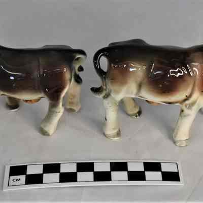 Back and size comparison of cow and bull salt and pepper shakers.