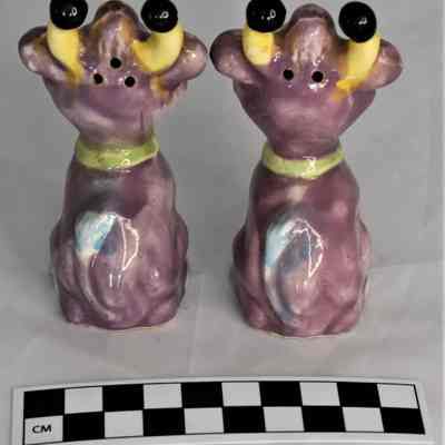 Back and size comparison of purple cows salt and pepper shakers.