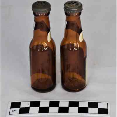 Back and size comparison of Schlitz beer bottle salt and peppers.