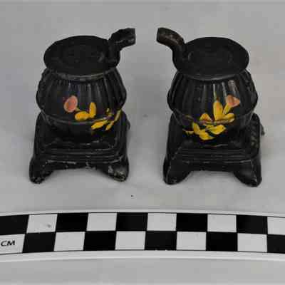 Back and size comparison of pot belly stove salt and pepper shakers.