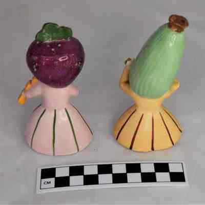Back and size comparison of anthropomorphic salt and pepper shakers.