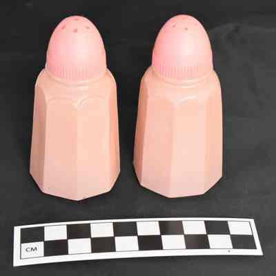 Other side and size comparison of pink glass salt and pepper shakers.
