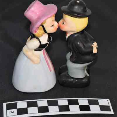 Other side and size comparison of kissing man and woman salt and pepper shakers.