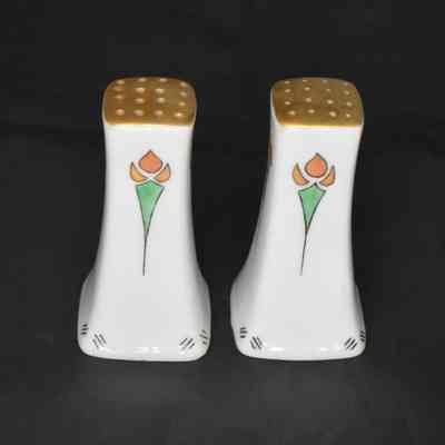 Vintage ceramic white salt and pepper shakers with a floral design.