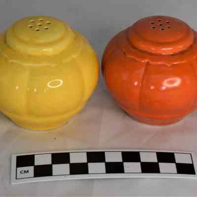 Other side and size comparison of yellow and orange shakers.