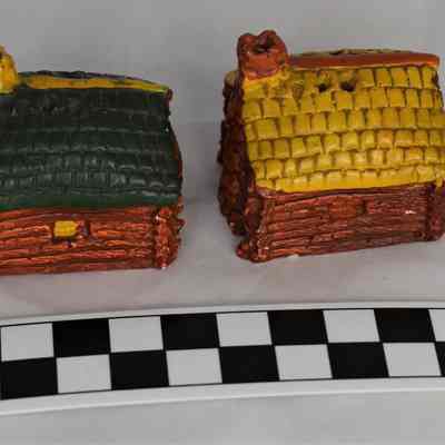 Back and size comparison of log cabin salt and pepper shakers.