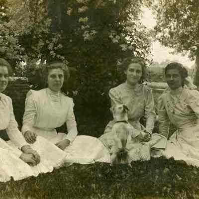 Four Women and a Dog Sitting on Lawn