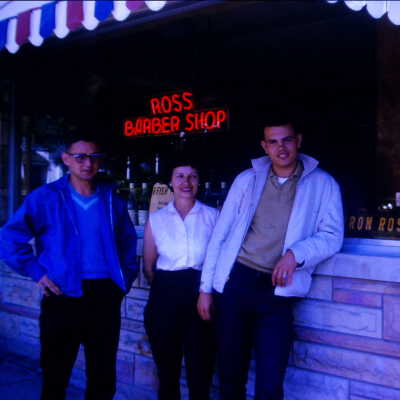 Woman and Two Younger Man Standing in Front of Ross Barber Shop