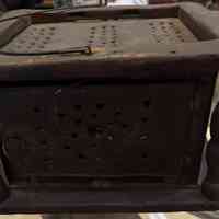         View of foot warmer with top of tin box visible.
   