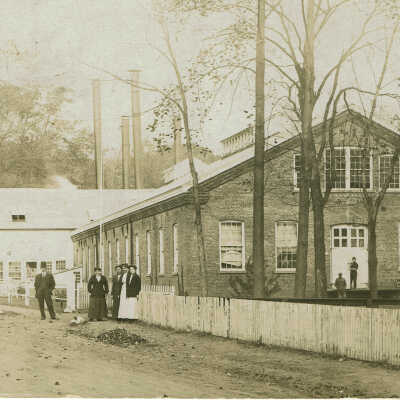 Diamond Mill with People Standing in Front of Brick Building