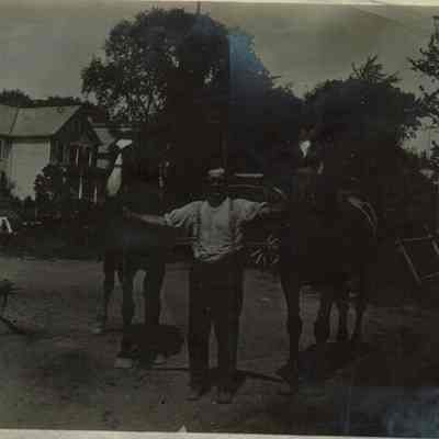 Marshall-Schmidt Album: Man Holding Two Horses in Yard