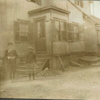 Marshall-Schmidt Photo Album: Boy and Girl Standing Outside a Wooden Building