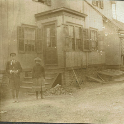 Marshall-Schmidt Photo Album: Boy and Girl Standing Outside a Wooden Building