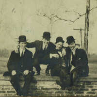 Four Men Seated on Brick Wall, c. 1900