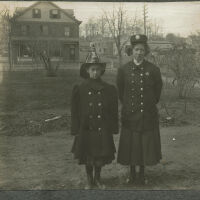 Marshall-Schmidt Album: Marion Marshall in Front of House in Fire Hat