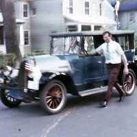 July 4: Man pushing antique car in American Bicentennial Parade, 1976