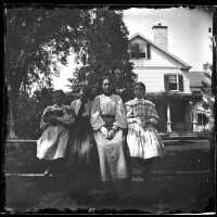 Blood: Girls Seated on a Stone Wall Outside Albert Blood House