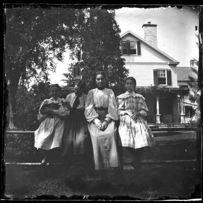Blood: Girls Seated on a Stone Wall Outside Albert Blood House