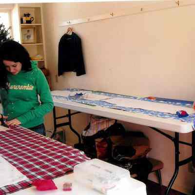 Students cut cloth for sewing class
