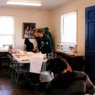 Students work at sewing table