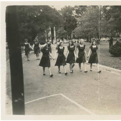 Black and White photograph of girls walking hand-in-hand