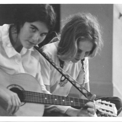 Susie Peebles with guitar and Lynn Comer Doramus, class of 1972