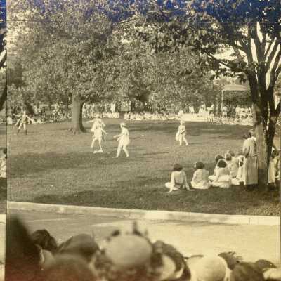 Belmont College for Women, circa 1919, women in white clothing walking around a tree with onlookers.
