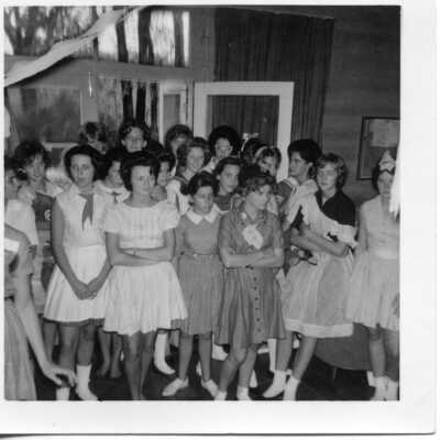 Students in short white dresses, possibly costumes in 1962.