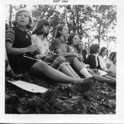 Group of students sitting outisde on the leaves in November of 1964.