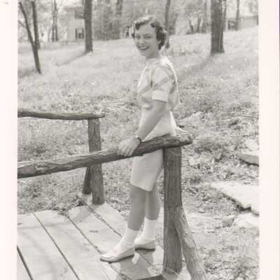 Student poses on wooden bridge, 1960s