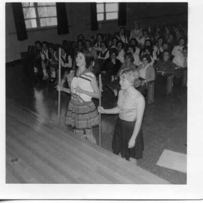 Students standing near the stage in the auditorium in 1962.