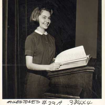 Student poses at podium, 1960s